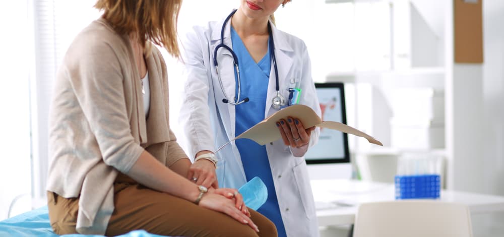 A doctor and patient sitting at a table, engaged in discussion. Medical consultation and healthcare concept.